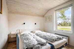 a bedroom with two beds in a room with a window at 30705-Ulfborg-Valmuevej-288 in Ulfborg