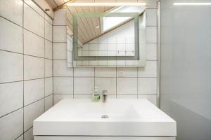 a bathroom with a white sink and a mirror at 30705-Ulfborg-Valmuevej-288 in Ulfborg +23 photos