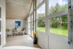 a large room with windows and a table and chairs at 30705-Ulfborg-Valmuevej-288 in Ulfborg