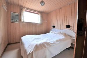 a bedroom with a bed in a room with a window at 30061-Ulfborg-Kaprifolievej-6 in Ulfborg