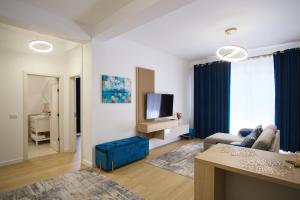 a living room with a couch and a tv at ASTI Residence Aparthotel in Năvodari