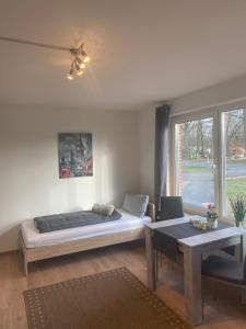 a bedroom with a bed and a table and a window at Ferienwohnung Neumann in Lentföhrden +30 photos