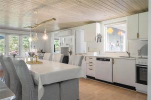 a kitchen with a white table and chairs in it at 30394-Ulfborg-Kaprifolievej-8 in Ulfborg