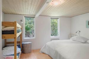 a bedroom with a bunk bed and two windows at 30394-Ulfborg-Kaprifolievej-8 in Ulfborg