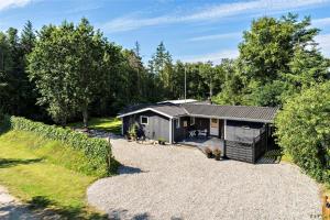 a tiny house in a garden with a gravel driveway at 30394-Ulfborg-Kaprifolievej-8 in Ulfborg