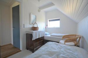 a bedroom with a bed and a sink and a mirror at 20261-Ulfborg-Vederso-Klitvej-20 in Ulfborg
