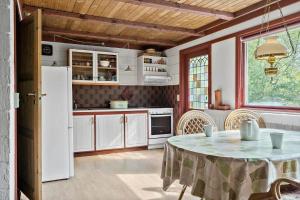a kitchen with a table and a white refrigerator at 30065-Ulfborg-Oster-skovvej-63 in Ulfborg +24 photos