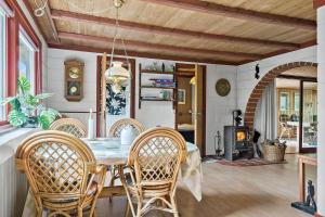 a dining room with a table and chairs and a fireplace at 30065-Ulfborg-Oster-skovvej-63 in Ulfborg