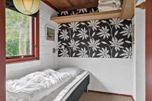 a bed in a room with a black and white wallpaper at 30065-Ulfborg-Oster-skovvej-63 in Ulfborg