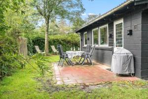 a patio with a table and chairs outside of a house at 30065-Ulfborg-Oster-skovvej-63 in Ulfborg