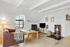 a living room with a table and a fireplace at 20356-Ulfborg-Lars-Murersvej-9 in Ulfborg