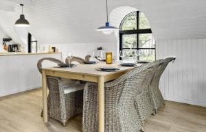 a dining room table with wicker chairs in a kitchen at 20356-Ulfborg-Lars-Murersvej-9 in Ulfborg +15 photos