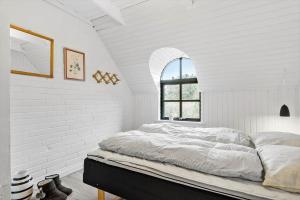 a white bedroom with a large bed with a window at 20356-Ulfborg-Lars-Murersvej-9 in Ulfborg