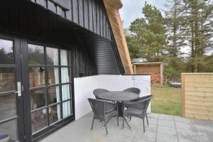 a patio with a table and chairs next to a building at 20356-Ulfborg-Lars-Murersvej-9 in Ulfborg