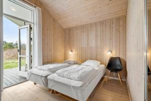 a bedroom with a bed and a sliding glass door at 60836-Ulfborg-Fjand-Strand-29 in Ulfborg
