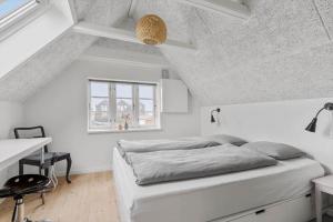 a white bedroom with a bed and a desk at 70222-Ulfborg-Jagtvejen-8 in Ulfborg