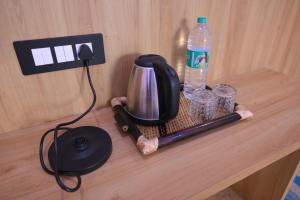 a coffee maker and a bottle of water on a table at SHIVAAY GARDEN in Kannauj