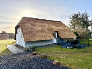 a house with a thatched roof on a field at 20362-Ulfborg-Sortebaervej-22 in Ulfborg