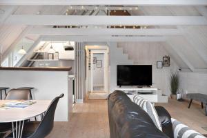 a living room with a couch and a tv at 20362-Ulfborg-Sortebaervej-22 in Ulfborg