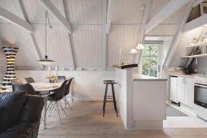 a kitchen and living room with a table and chairs at 20362-Ulfborg-Sortebaervej-22 in Ulfborg +25 photos
