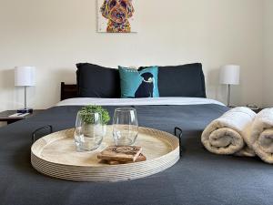 a bed with a table with two glasses and towels at Bark and Bike Abode home in Fruita