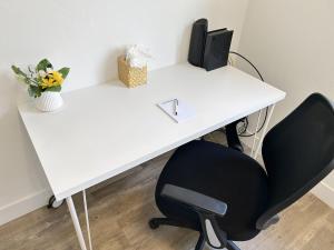 a white desk with a computer and a chair at Bark and Bike Abode home in Fruita