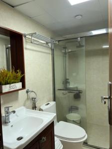 a bathroom with a sink and a toilet and a shower at KMRP Condo Unit in Baguio
