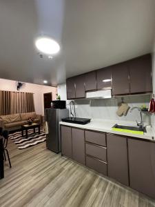 a kitchen with a counter top and a living room at KMRP Condo Unit in Baguio