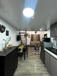 a kitchen and living room with a table and a couch at KMRP Condo Unit in Baguio