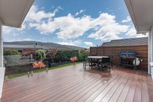 a patio with a table and chairs on a deck at Roslyn Sanctuary Highgate Dunedin in Dunedin