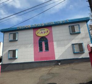a building with a sign on the side of it at ホテルパルシス大人専用 in Shiroishi