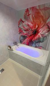 a bathroom with a bath tub with a flower mural at ホテルパルシス大人専用 in Shiroishi
