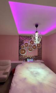 a room with a bed and a pink ceiling with donuts at ホテルパルシス大人専用 in Shiroishi
