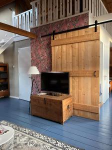 a television on a wooden chest in a living room at Familie- en Groepsverblijf Het Voorhuis in Loon op Zand