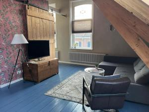 a living room with a couch and a television at Familie- en Groepsverblijf Het Voorhuis in Loon op Zand +20 photos