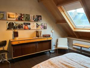 a bedroom with a desk and a bed and a window at Familie- en Groepsverblijf Het Voorhuis in Loon op Zand