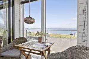 a table and chairs on a porch with a view of the ocean at SL324-Slagelse-Strandvaenget-29 in Slagelse