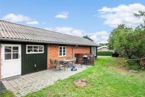 a brick house with a table and chairs in a yard at SL283-Slagelse-Havesangervej-2 in Slagelse