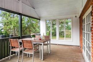a porch with a wooden table and chairs and windows at SL283-Slagelse-Havesangervej-2 in Slagelse +13 photos
