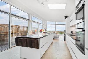 a kitchen with white cabinets and a large window at SL287-Slagelse-Strandvaenget-14 in Slagelse