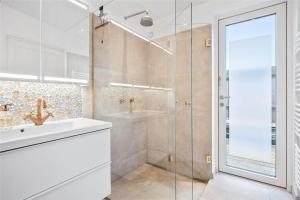 a bathroom with a glass shower and a sink at SL287-Slagelse-Strandvaenget-14 in Slagelse