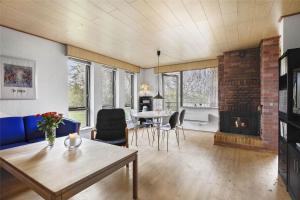 a living room with a table and a fireplace at SL122-Slagelse-Delfivej-6 in Slagelse