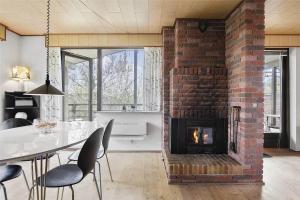 a brick fireplace in a living room with a table and chairs at SL122-Slagelse-Delfivej-6 in Slagelse
