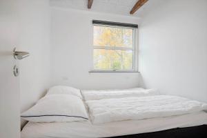 a white room with a bed with a window at SL301-Korsor-Strandengen-1 in Korsør