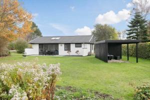 a white house with a black roof in a yard at SL301-Korsor-Strandengen-1 in Korsør