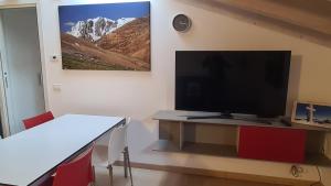 a living room with a tv and a table with a television at Namastè in Mandello del Lario
