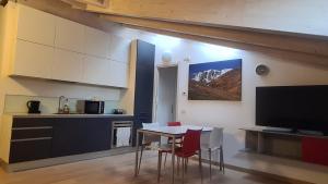 a kitchen and dining room with a table and a television at Namastè in Mandello del Lario