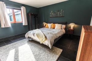 a bedroom with a bed and a green wall at New House Barn in Ashbourne