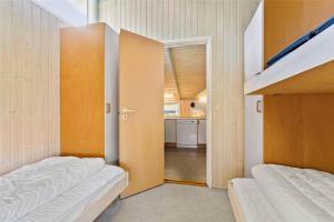 a bedroom with two bunk beds and a kitchen at K20031-Kalundborg-Kystagervej-29 in Kalundborg