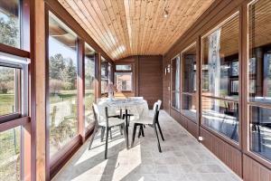a dining room with a table and chairs and windows at K20061-Gorlev-Eranthisvej-7 in Gørlev